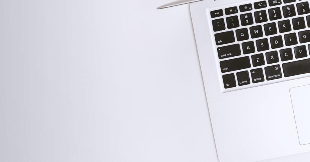 Aerial view of a sleek laptop keyboard on a clean, white surface, ideal for tech backgrounds.