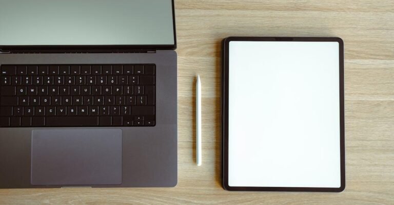 Top view of a sleek laptop and tablet setup on a wooden desk, ideal for tech workspaces.