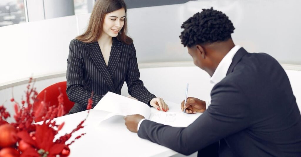 A professional setting with two business people signing a contract in an office environment.